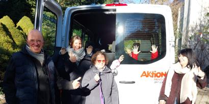 Menschen hinter einem Bus von Aktion Mensch