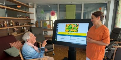 Bewohnerin und Betreuerin mit digitalem Aktivitätstisch