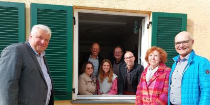 Spender und Diakonievertreter an einem Fenster mit neuen Fensterläden.