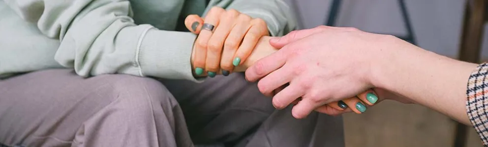 Frau hält einer anderen Frau die Hand