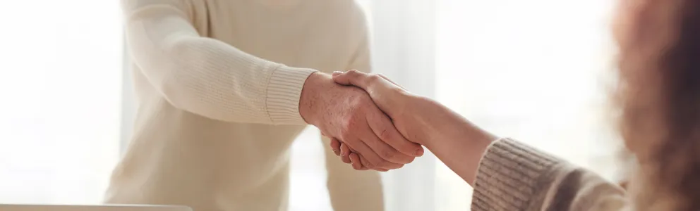 Mann begrüßt Frau mit Handschlag