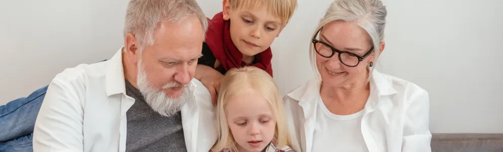 Oma und Opa lesen mit ihren Enkelkindern ein Buch