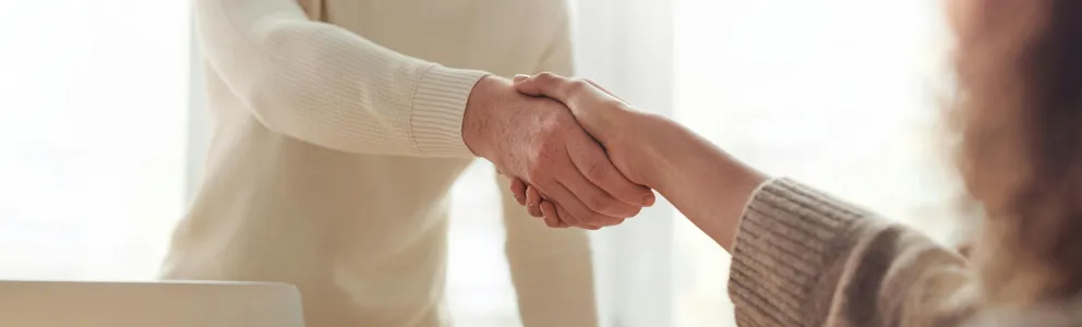 Handschlag zwischen Mann und Frau am Schreibtisch