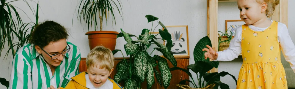Frau spielt mit Kindern mit einer Eisenbahn
