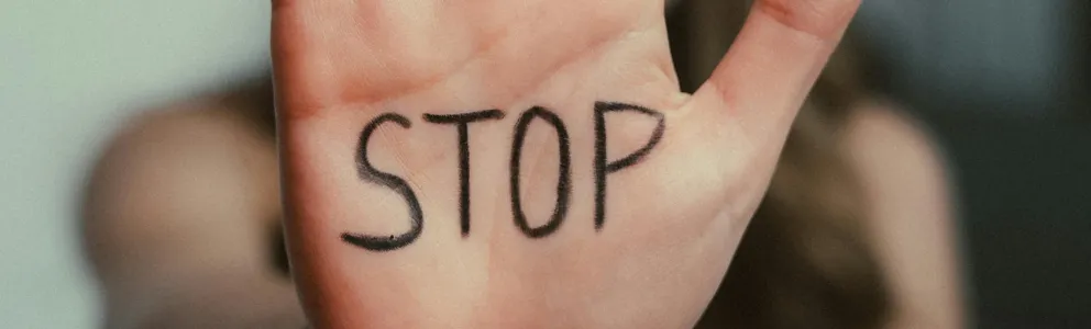 Eine Frau hält ihre Han in die Kamera, darauf steht "Stop"