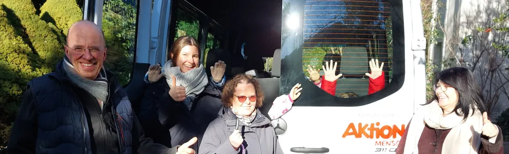 Menschen hinter einem Bus von Aktion Mensch