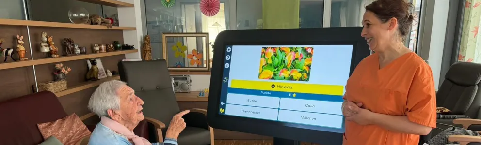 Bewohnerin und Betreuerin mit digitalem Aktivitätstisch