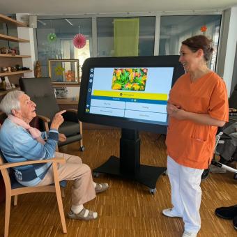 Bewohnerin und Betreuerin mit digitalem Aktivitätstisch