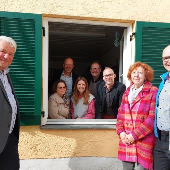 Spender und Diakonievertreter an einem Fenster mit neuen Fensterläden.
