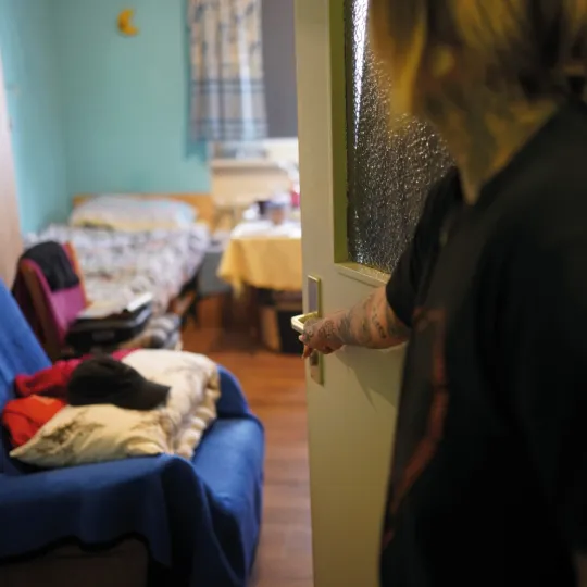 Frau öffnet Wohnungstür